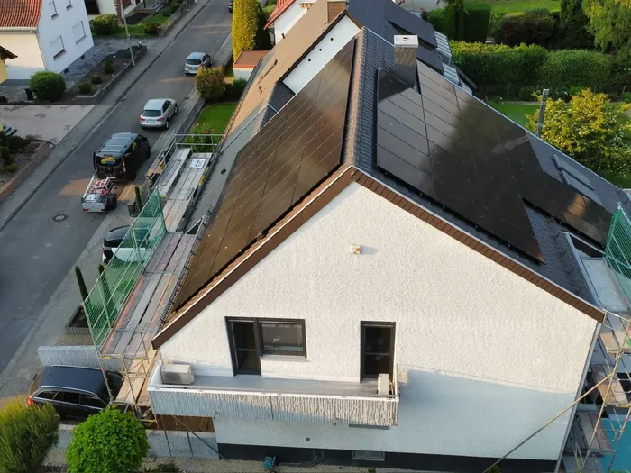Luftaufnahme eines Hauses mit Photovoltaik auf beiden Dachseiten